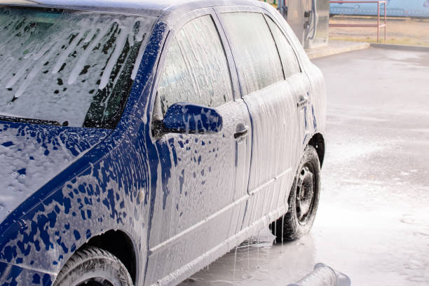 istock Blue car in foam at a car wash 1353756806
