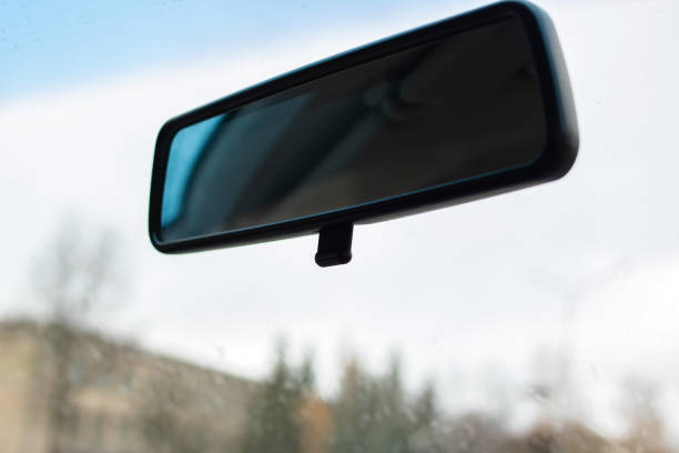 Rearview mirror in the car on sky background close up