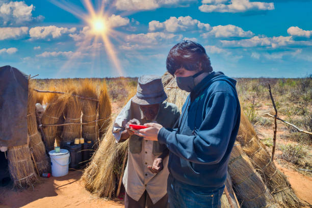 istock young man from an ngo using the phone with an old man 1353758504
