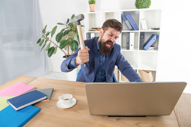 espressione facciale. stress e pressione sul posto di lavoro. uomo d'affari che tiene il martello. impiegato frustrato. software obsoleto. lottare per il successo. problema irreversibile del sistema. il pc dell'ufficio si blocca - problems computer pc frustration foto e immagini stock