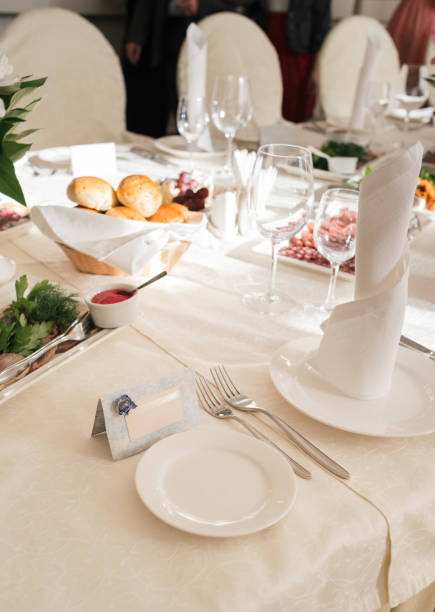 istock Blank card for guests near white empty plate on dinner table for wedding banquet, free space for text 1353759666