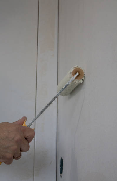 istock Hand working with paint roller, wall painting concept 1353761169