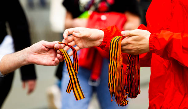 istock St. George's ribbons and people's hands close-up 1353761655