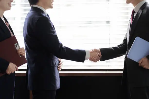 Asian business person shaking hands