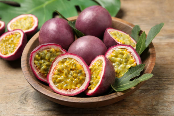 istock Cut and whole passion fruits (maracuyas) on wooden table 1353762044