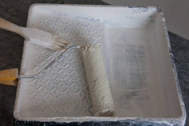 istock Painter's construction tool after painting, roller and brush in a container for painting. 1353762117