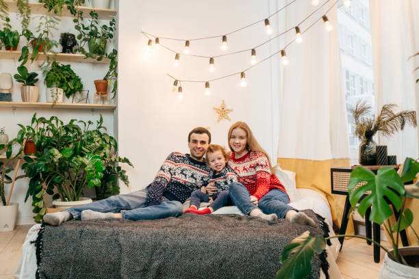 istock Happy family in Christmas sweaters on bed. 1353762790