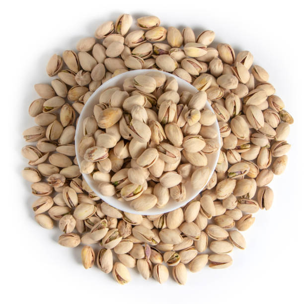 istock White bowl of pistachios on white background top view 1353764663