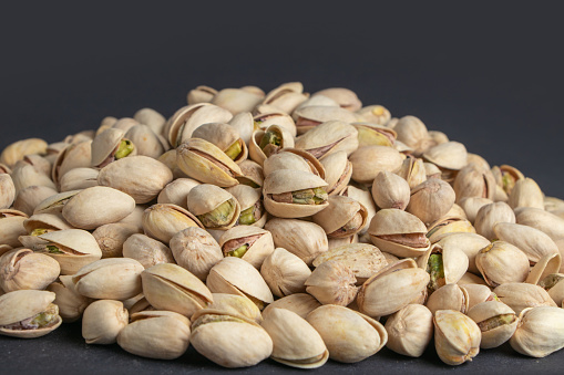Pile of pistachios in the peel close-up on a dark background