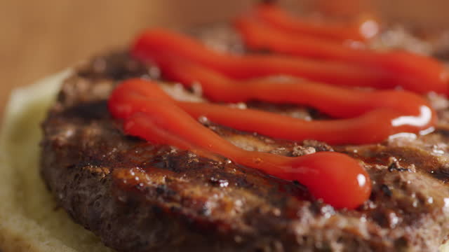 Closeup shot of putting ketchup on hamburger.  Shot on RED 8K camera.