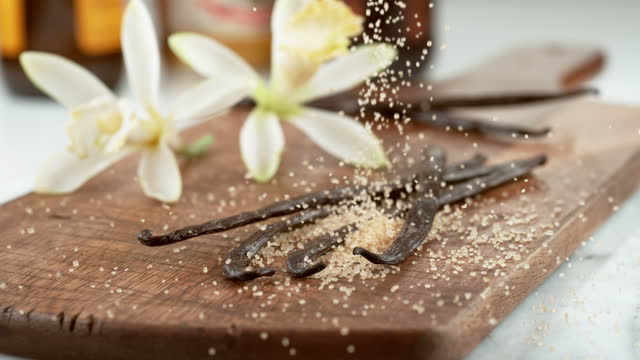 Raw sugar falling onto vanilla beans in slow motion.  Shot on Phantom Flex 4K camera.