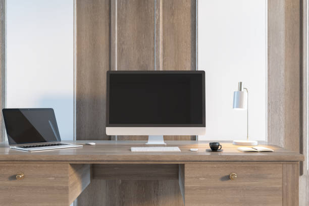 istock Antique wooden desk with empty computer and laptop monitors, table lamp, coffee cup and other items. Workpace and office workspace concept. Mock up, 3D Rendering. 1353767751