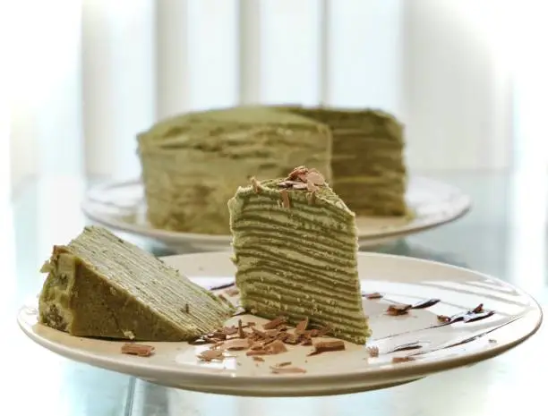 Close up picture of homemade matcha mille crepe cake, with chocolate shavings