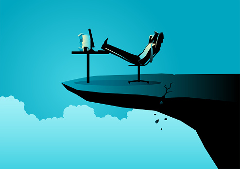 Businessman relaxing on his chair on the cracked cliff edge, comfort zone, risk, danger concept