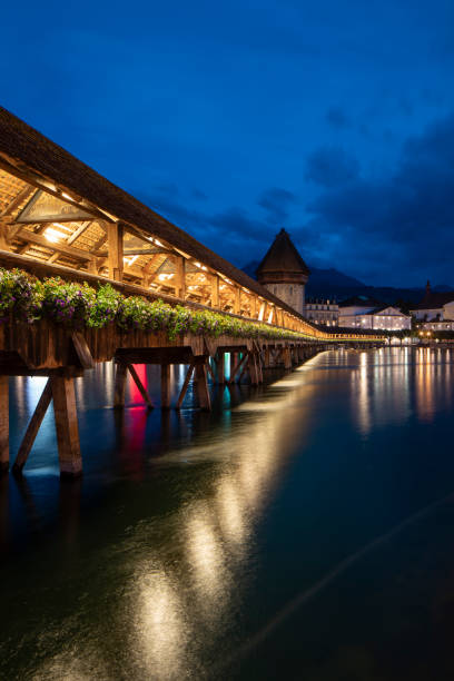 Kapellbrücke, medieval bridge in Luzern at night. The bridge is illuminated, the lights are reflected in the lake Kapellbrücke, medieval bridge in Luzern at night. The bridge is illuminated, the lights are reflected in the lake. Impressive view of the city lucerne switzerland stock pictures, royalty-free photos & images