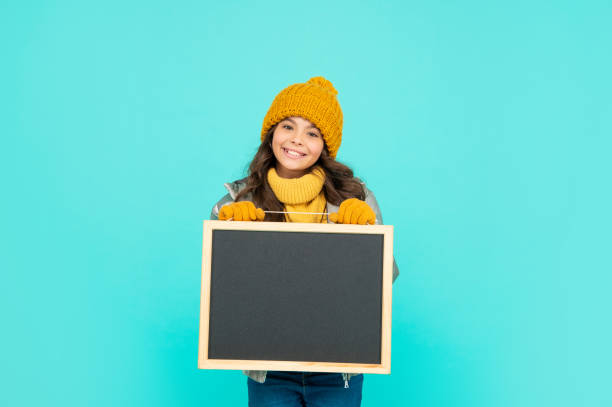 istock back to school. cheerful kid in hat hold blackboard. childhood. 1353777004