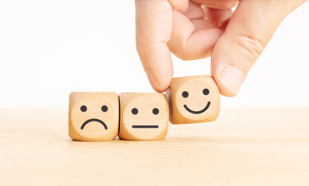 Customer service evaluation concept Customer service evaluation concept. Hand picking the happy face emoticon on wooden block consumer confidence photos stock pictures, royalty-free photos & images