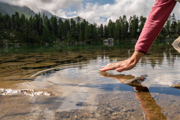 istock Hand touching water from alpine lake 1353780005
