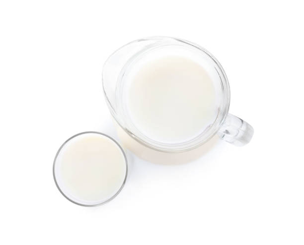 istock Jug and glass with fresh milk on white background, top view 1353780373