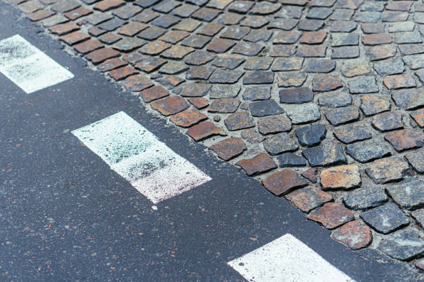 istock Paving stones pathway and asphalt with markings texture. Cobblestone and asphalt background 1353781988