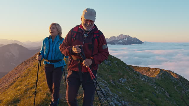 SLO MO Elderly couple of hikers walks on the ridge of a mountain