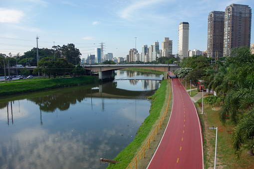 polluted Pinheiros river in Sao Paulo, Brazil. bike lane and buildings cityscape. High quality photo