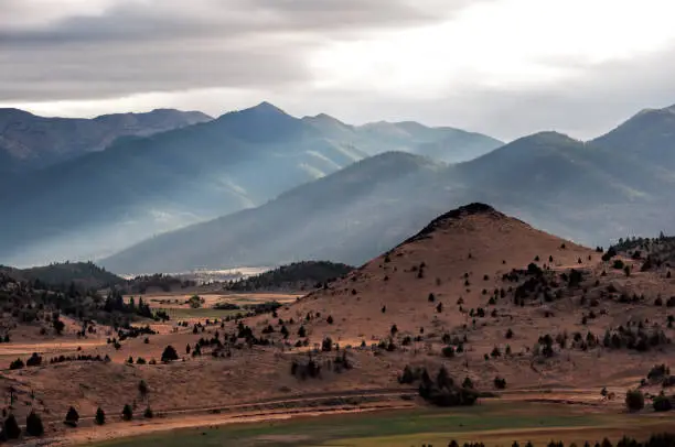 The sun peeks through the clouds near Mount Shasta in the Fall, California, USA.