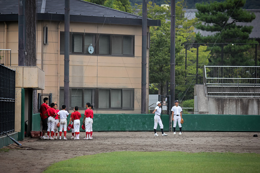 Kyoto, Japan - august 23 2019: Coach gives instructions to children playing baseball