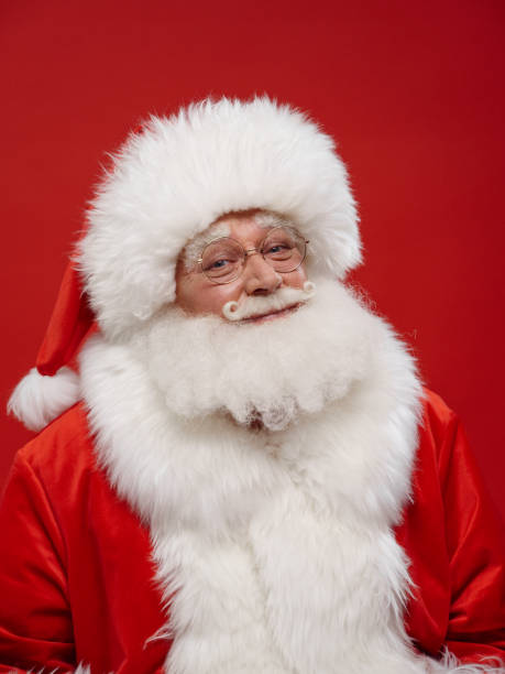 istock kind Santa looks at us with the red background behind him 1353790933