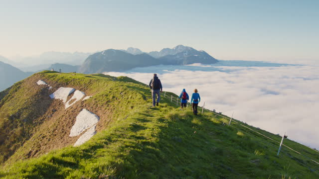 SLO MO Hikers walks on the ridge of a mountain