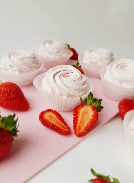 istock Pink strawberry homemade marshmallows on a white background on a cutting board side view, close-up, selective focus. 1353794290