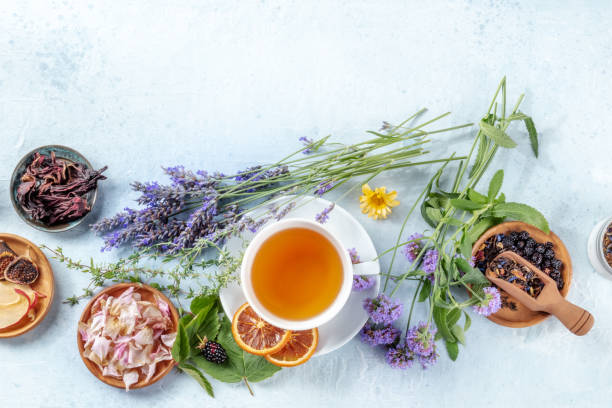 A cup of tea with dry fruit, flowers, and herbs, shot from the top stock photo