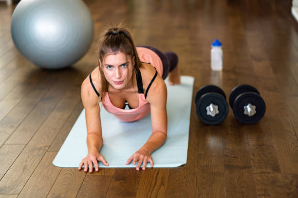 istock Woman in plank position at home 1353794469