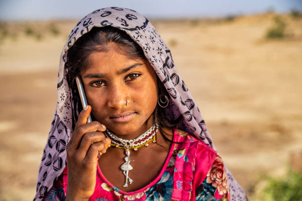 istock Happy Gypsy Indian girl using smart phone, India 1353794645