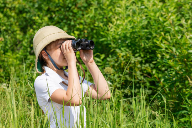 istock Young explorer looking through binoculars outdoors 1353794793