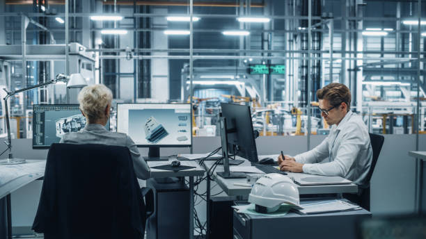 istock Team of Automotive Engineers Working on Desktop Computers in Modern Office at Car Assembly Plant. Industrial Product Designer Developing Electric Engine Parts with Colleagues at Vehicle Factory. 1353796871