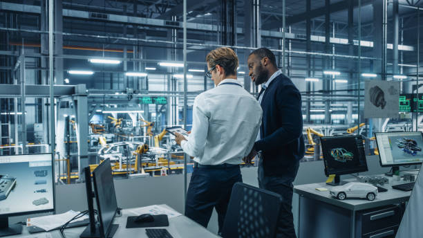 istock Two Diverse Automotive Industrial Engineers Talking About Vehicle Production while Standing in Office at a Car Assembly Plant. Industrial Specialists Discuss Work Projects on Tablet Computer. 1353797006
