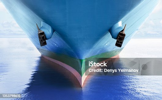 istock Front view of large blue merchant cargo ship in the middle of the ocean. Performing cargo export and import operations. 1353798615