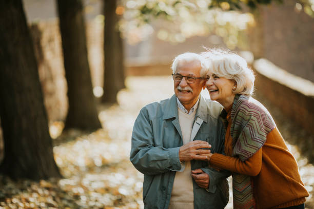 istock Senior couple walking in autumn park 1353800033