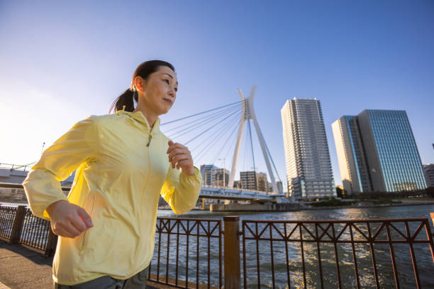 istock Woman running at riverside in city 1353801083