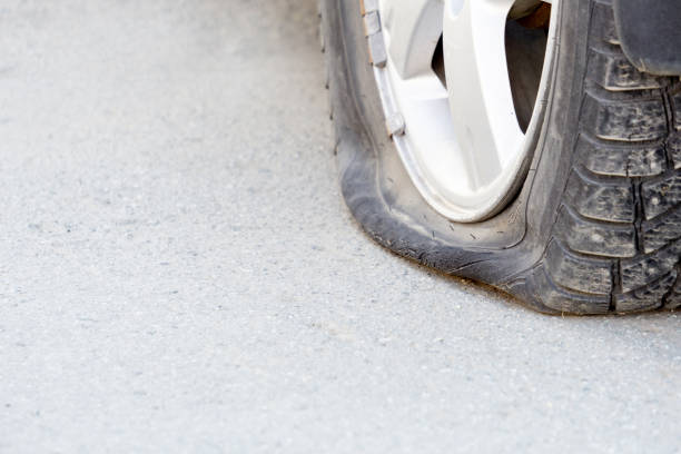 istock Flat tire on a white background. A punctured car tire. 1353801206