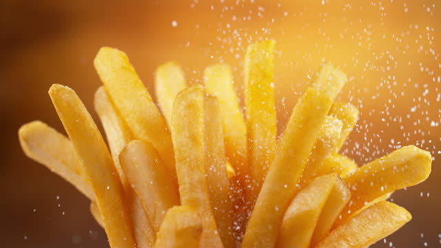 Salt falling onto French fries in slow motion.  Shot on Phantom Flex 4K camera.