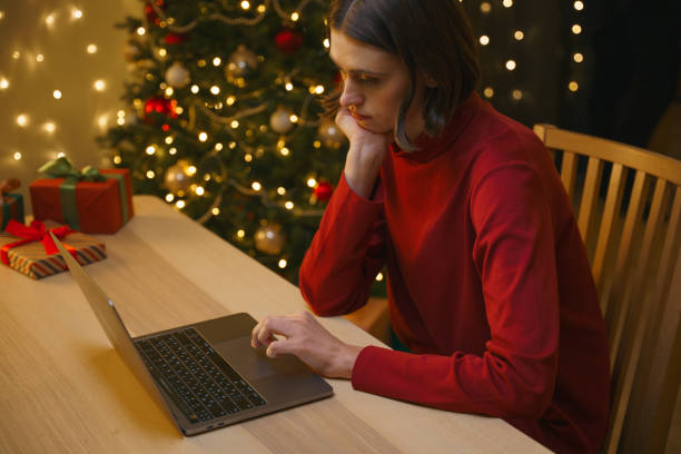 istock A young pretty student in a red sweater works at home before Christmas, thoughtfully looking in her laptop 1353803187