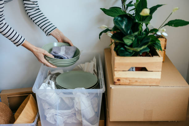 istock Anonymous Woman Packing Things in a Plastic Box Ready for Relocation 1353805165