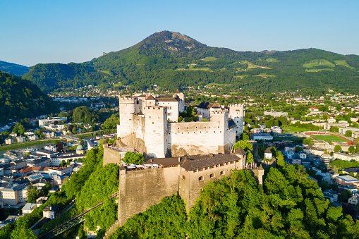 Salzburg, Austria - May 11, 2022: View of the old town and the Hohensalzburg Fortress, with the Salzach river in the foreground.