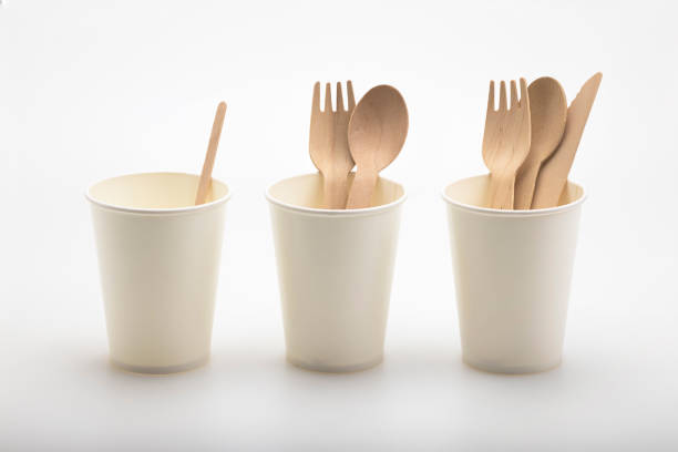 istock Wooden spoon and fork with knives in paper cup  , disposable tableware on a white background. Eco-friendly materials 1353806812