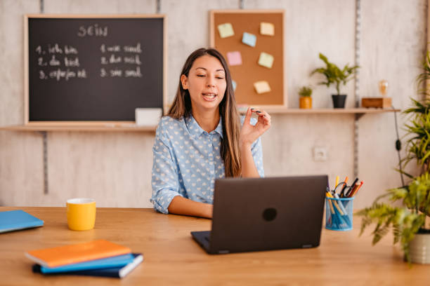 Female teacher giving German language lesson online Happy teacher woman giving German language lesson in live, broadcasting class during the Coronavirus, using laptop. online tutors stock pictures, royalty-free photos & images