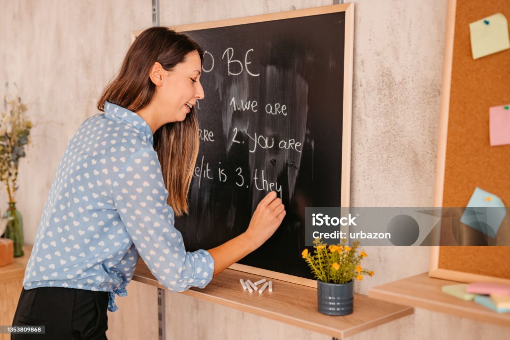 Female teacher giving English language lesson online Happy teacher woman giving English language lesson in live, broadcasting class during the Coronavirus. Camera point of view. Adult Stock Photo