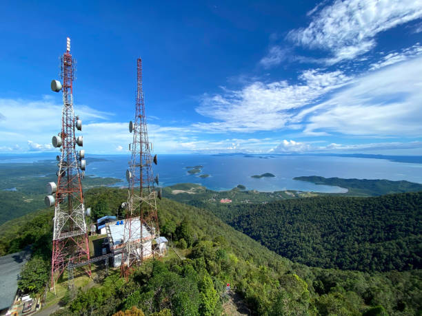 tours de télécommunication au sommet de collines verdoyantes surplombant la mer. concept de télécommunications. - munt tower photos et images de collection