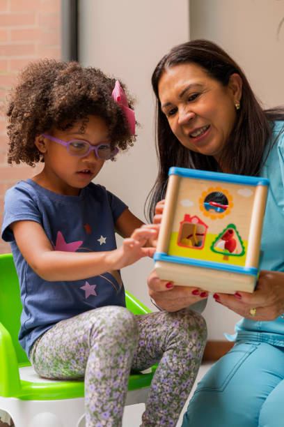 Physiotherapist doctor performs exercises to her patients sensory therapy girls Physiotherapist doctor performs exercises to her patients sensory therapy girls montessori stock pictures, royalty-free photos & images
